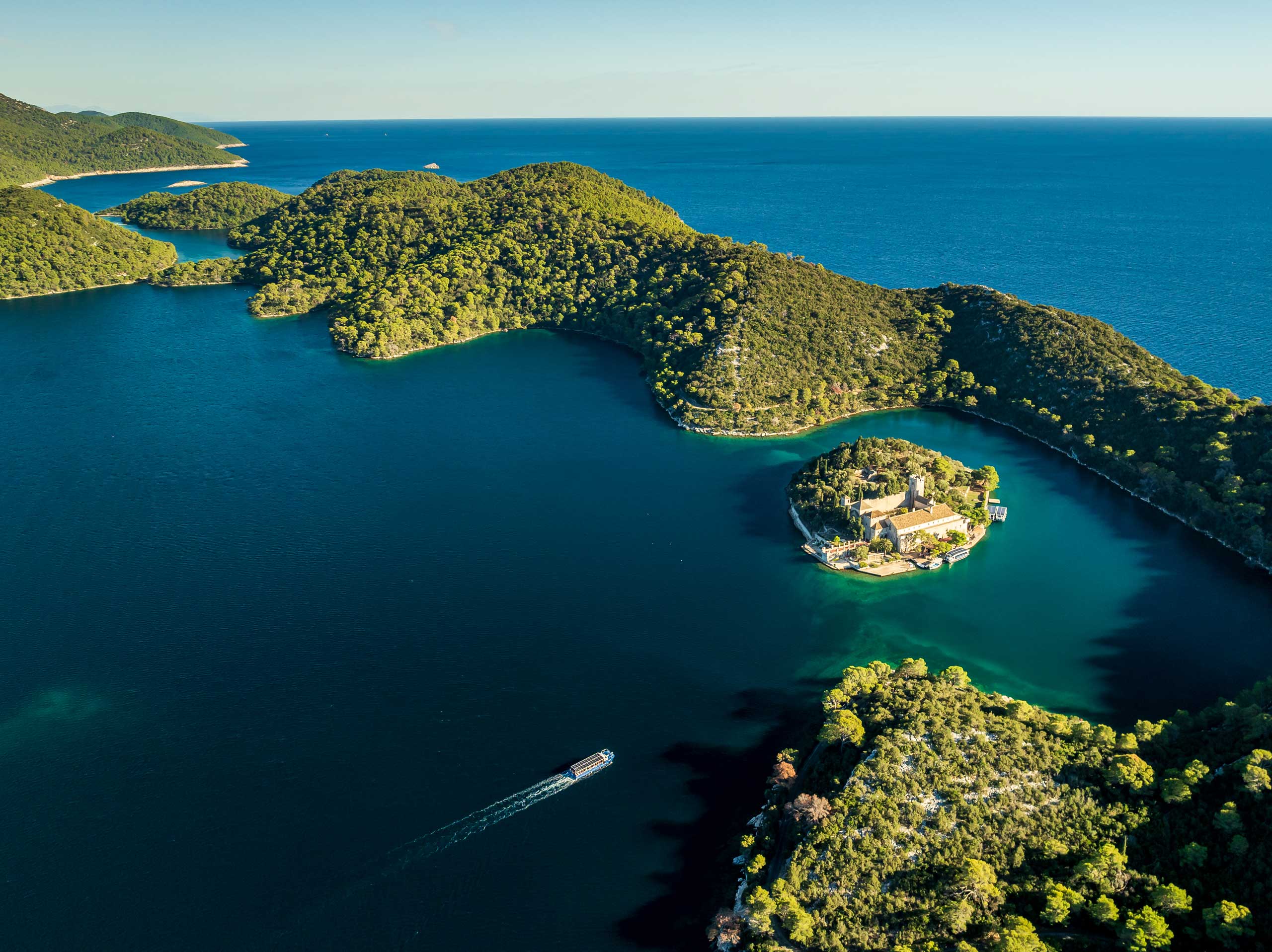 Nordwestlich von Dubrovnik gelegen, gehört die Insel Mljet zu den grünsten der Adria. Im Nationalpark prägen dichte Wälder und zwei Salzwasserseen das Bild, während weite Teile der Küste bewusst unberührt bleiben.